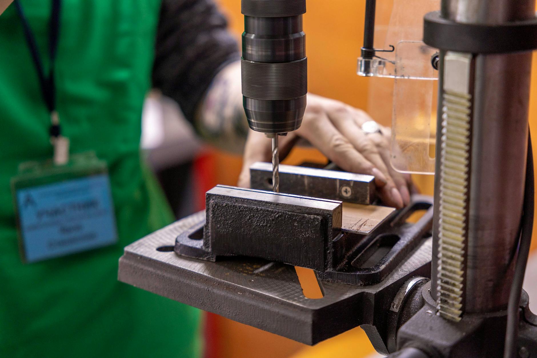 Dłoń obsługująca frezarkę w warsztatowym otoczeniu