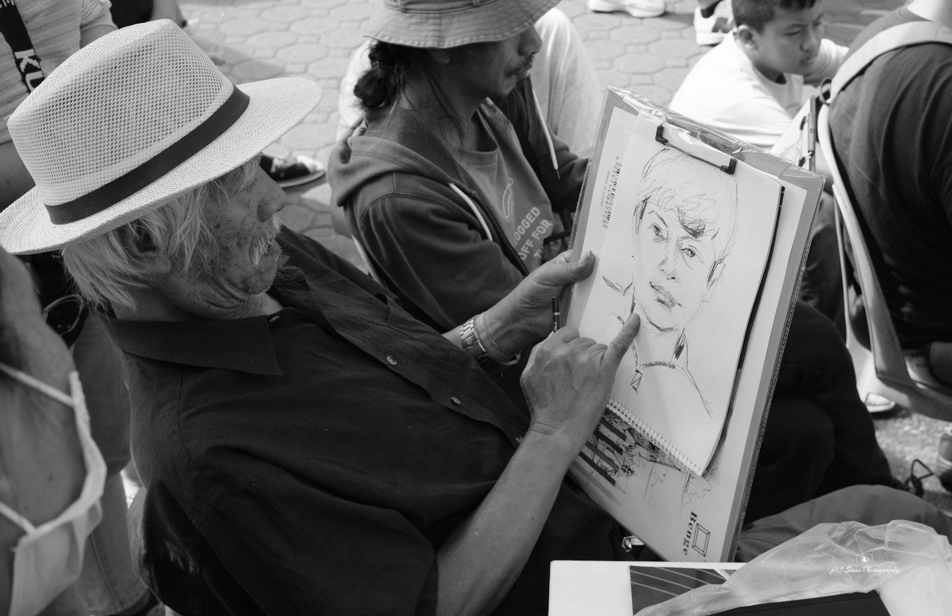 Artysta szkicuje portret z natury na dworze, czarno-białe ujęcie Artysta szkicuje portret z natury na dworze, czarno-białe ujęcie