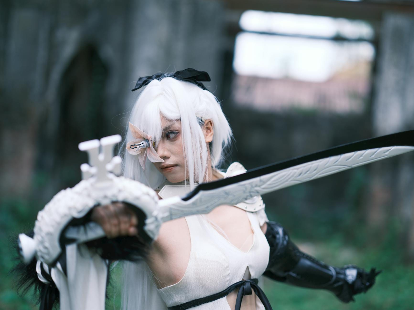 Cosplayer z mieczem pośród starych ruin w azjatyckim stylu