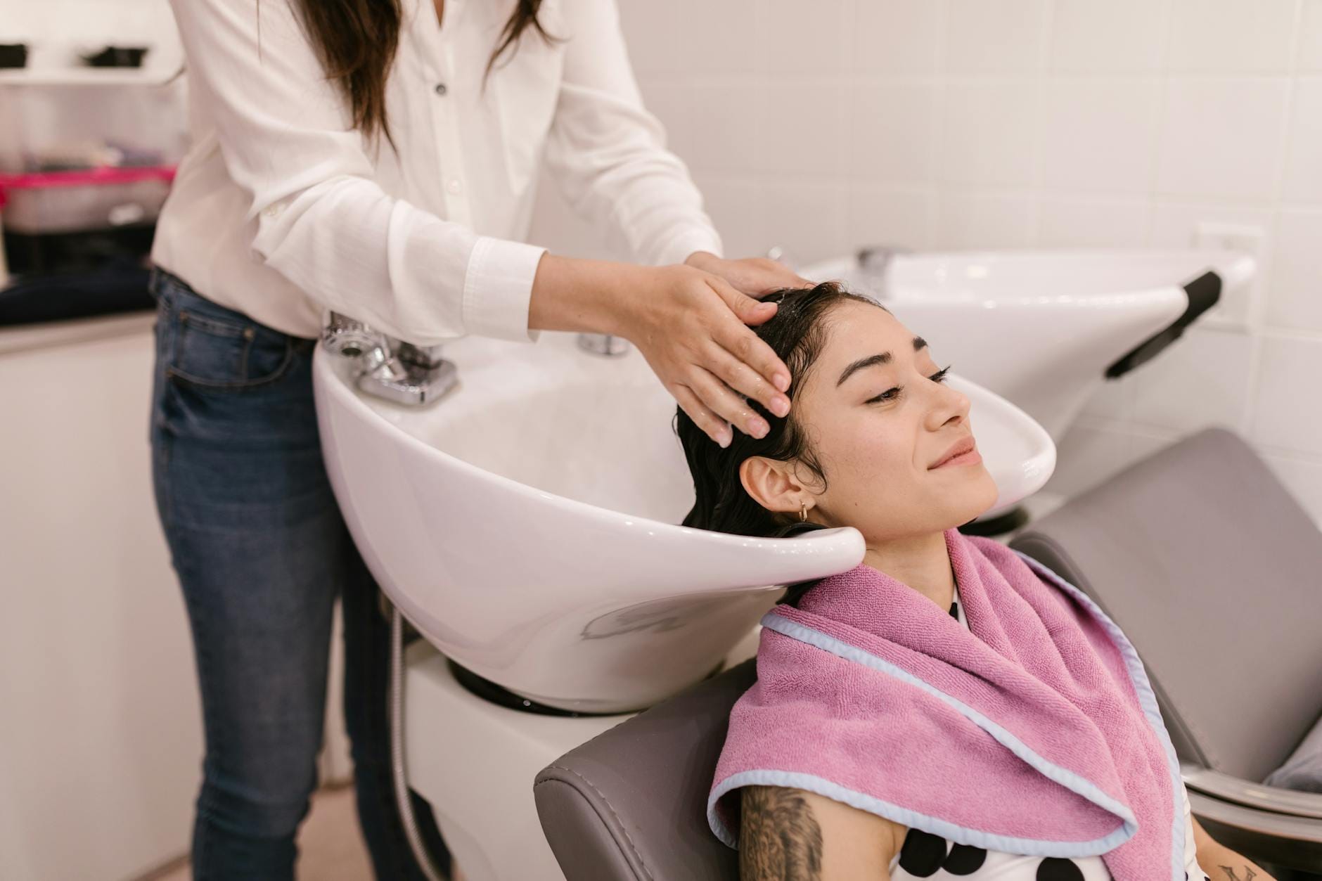 Klientka relaksuje się podczas mycia włosów w nowoczesnym salonie
