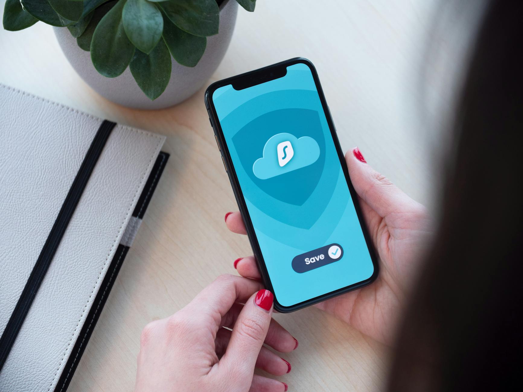 Kobieta trzyma smartfon z aplikacją prezentującą szyfrowanie danych