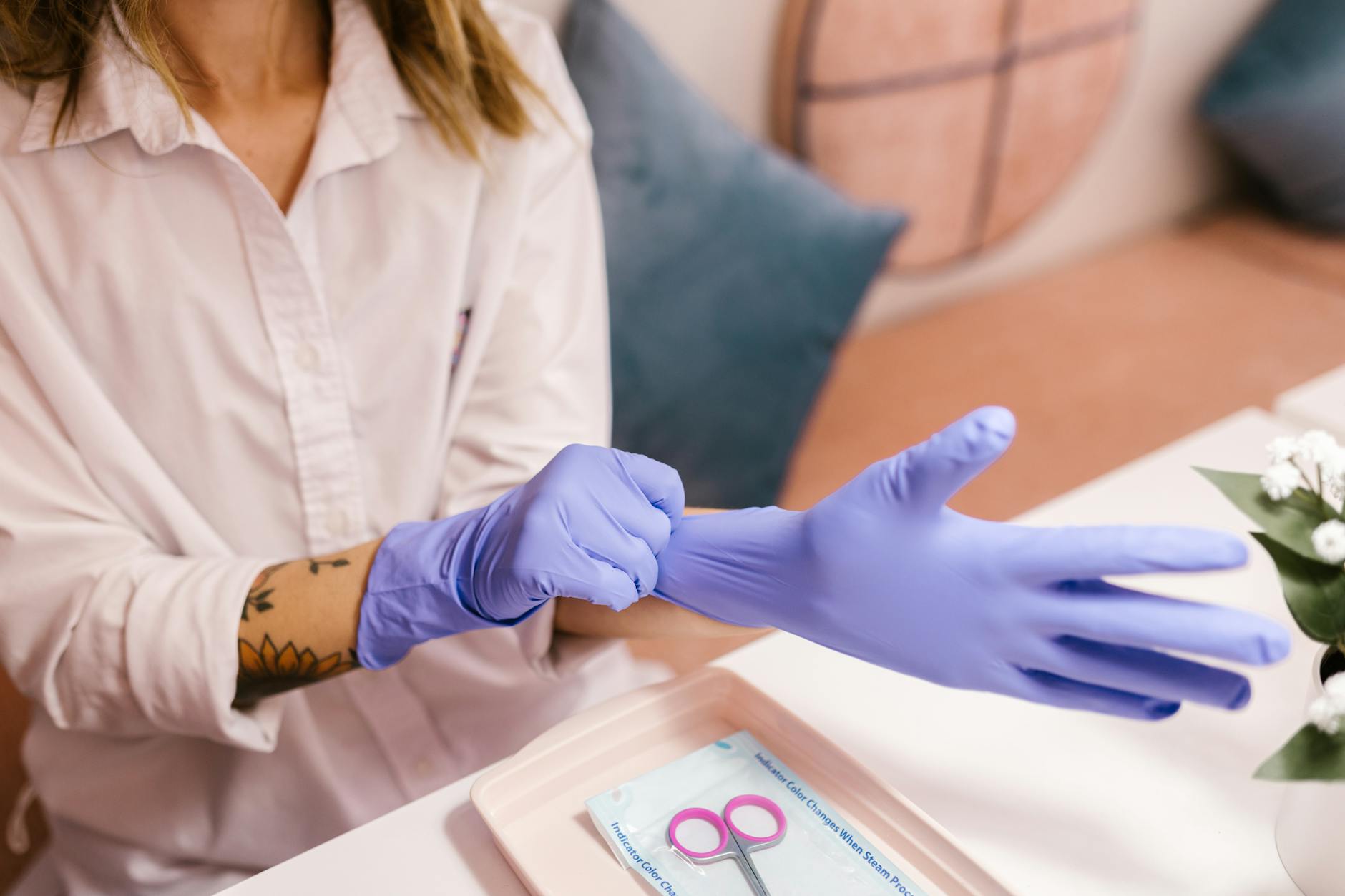 Kobieta w salonie zakłada niebieskie rękawiczki przed zabiegiem spa