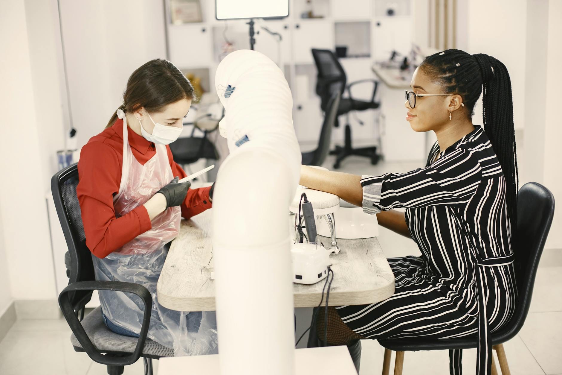 Manicurzystka wykonuje zabieg klientce w nowoczesnym salonie manicure