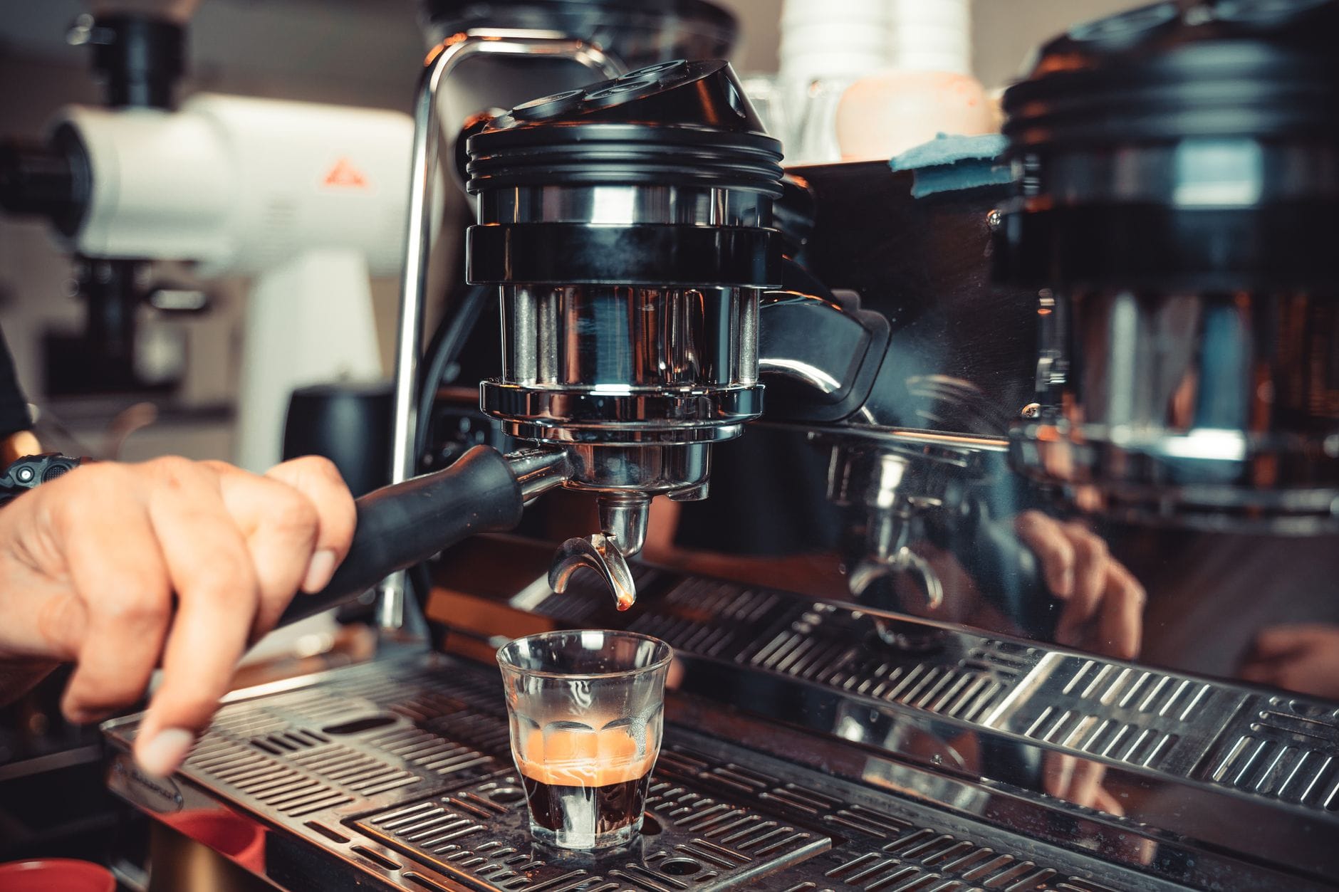 Barista przygotowuje espresso na kolbowym ekspresie z bliska